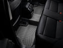 The image shows the backseat of a car with black leather seats and fitted WeatherTech Floorliner mats for BMW X4 (2010-2018)(F26) / X3 (2010-2017)(F25) 2nd row, protecting the carpet with textured grooves.
