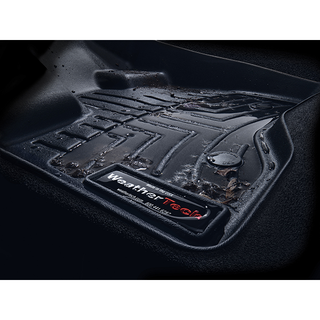 A close-up of a WeatherTech FloorLiner HP for Jeep Wrangler (2018-) 1st Row, showing its textured black surface with water, dirt, and debris, highlighting its superior interior protection.