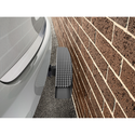 A vehicle with a Weathertech BumpStepXL 24 - AU Version (Standard Plated Hitch Hardware) is parked very close to a brick wall, leaving minimal space between the rear bumper and the wall.