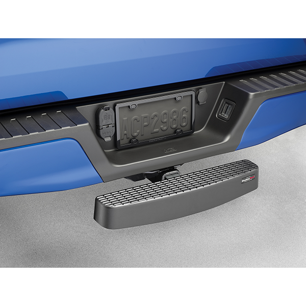 A close-up of a blue truck’s rear bumper shows a Weathertech BumpStepXL 24 - AU Version with standard plated hitch hardware mounted in the receiver hitch, providing bumper protection and easier access to the truck bed.