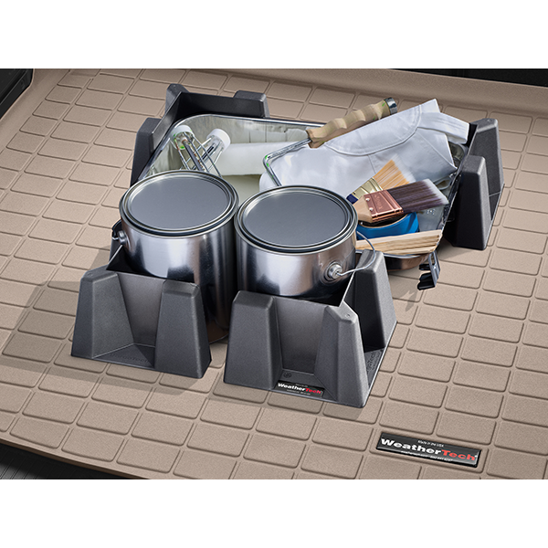 Two metal paint cans, brushes, a roller, and cloth stay secure with the WeatherTech Cargo Tech containment system—durable plastic holders keep items stable on the beige textured WeatherTech mat during transport.
