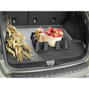 The image shows a Weathertech Cargo Tech cargo containment system organizing corn stalks, a basket of apples, and three jugs of apple cider in a car trunk with a rubber cargo liner.