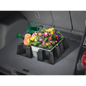 A car trunk holds a plastic bin of colorful artificial flowers, a green watering can, and an orange flower pot, all secured by the WeatherTech Cargo Tech cargo containment system.