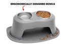 The WeatherTech Double Elevated Pet Feeding System features two raised stainless steel bowls—one filled with kibble, one empty—with some kibble scattered below. Text above reads “Ergonomically Designed Bowls.” Brand: WeatherTech.