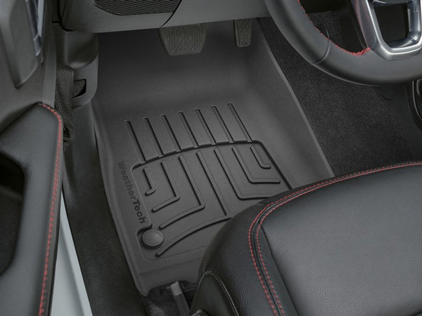 Close-up of a Jeep Gladiator (2020-) 2nd row footwell with a WeatherTech FloorLiner HP for top interior protection, plus a glimpse of a black leather seat with red stitching.