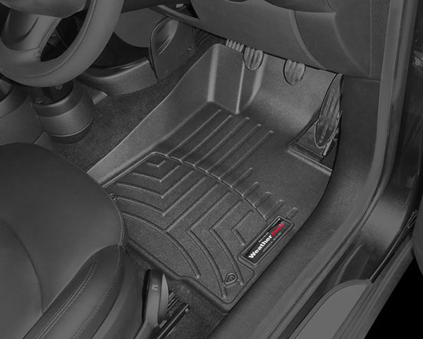 The Weathertech Floorliner for Mini Countryman R60 (2011-2017), 1st Row, fits the driver’s side footwell, protecting the carpet beneath the pedals with durable grooved black rubber and features a branded label at the bottom right corner.