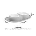 The WeatherTech Double Compact Pet Feeding System features two white 32 oz ergonomic pet bowls on a light grey oval base (12.75" D x 20.25" W x 2.75" H), making it a space-saving feeder for your home.