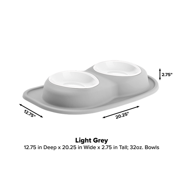 The WeatherTech Double Compact Pet Feeding System features two white 32 oz ergonomic pet bowls on a light grey oval base (12.75" D x 20.25" W x 2.75" H), making it a space-saving feeder for your home.