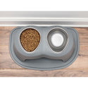 The WeatherTech Double Elevated Pet Feeding System by Weathertech is shown in gray, placed on a wooden floor near a wall, with one bowl filled with dry kibble and the other empty on a matching gray mat.