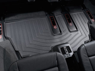A close-up view of black WeatherTech FloorLiner for BMW X5 (E70) 2007-2013 3rd row installed in a vehicle’s rear, offering superior floor protection and showing visible air vents behind the center console.