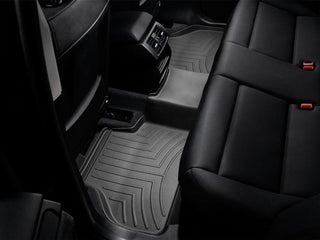 The image shows the backseat of a car with black leather seats and fitted WeatherTech Floorliner mats for BMW X4 (2010-2018)(F26) / X3 (2010-2017)(F25) 2nd row, protecting the carpet with textured grooves.