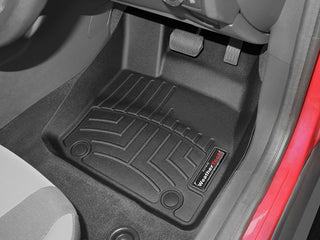 A WeatherTech Floorliner for Ford Focus (2015-2016) 1st row is installed on the driver’s side, covering carpet beneath pedals and seat, with textured grooves and a WeatherTech logo for top floor protection.