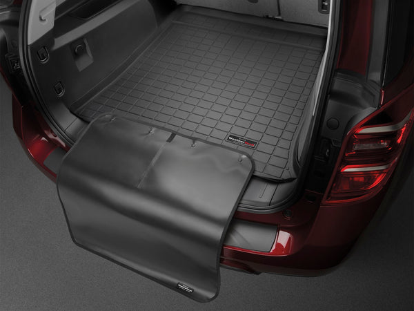A close-up of a MINI Countryman (U25) trunk shows a black WeatherTech CargoLiner with a fold-out bumper flap. The liner fits neatly in the cargo space, providing reliable protection for your vehicle.