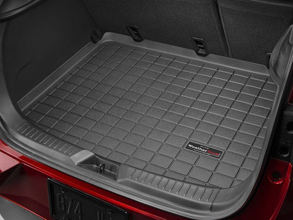 A close-up of the open trunk of a Mazda CX-3 (2016-2021) with a WeatherTech Cargo Liner. The raised grid pattern provides complete cargo area protection, fitting snugly to cover the entire trunk floor.