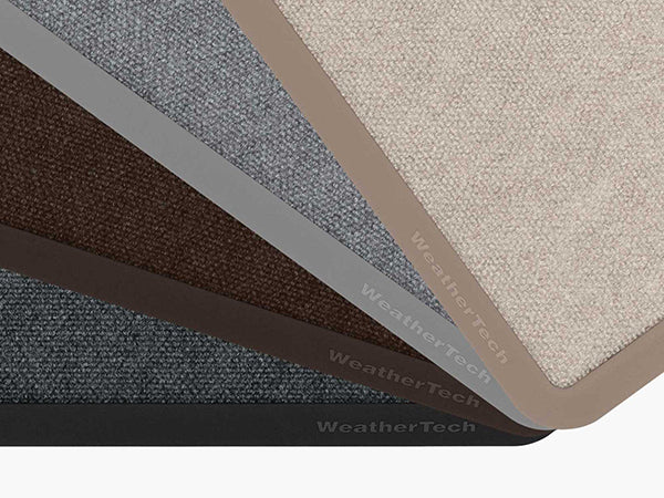 Five Weathertech Carpet Mats in beige, light gray, brown, gray, and black are fanned out to show texture and color options. Each mat features the Weathertech logo and delivers commercial-grade durability.